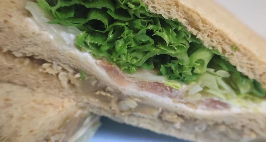 A close-up of a sandwich with lettuce and other fillings.
