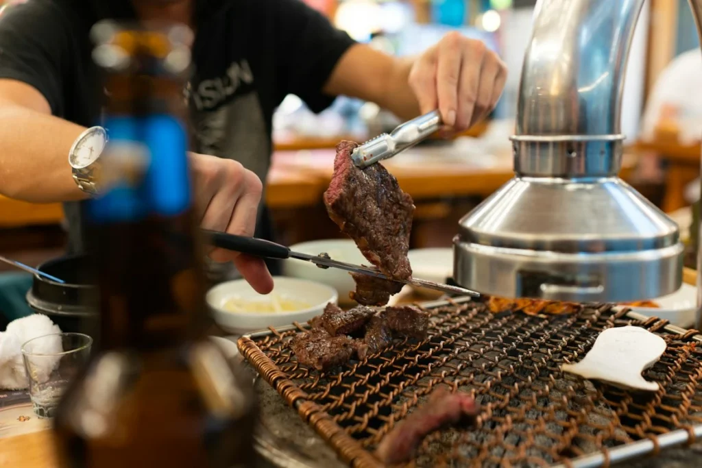 Beef cooking on a tabletop grill in Seoul. Check the serving weight and minimum order before choosing a restaurant.