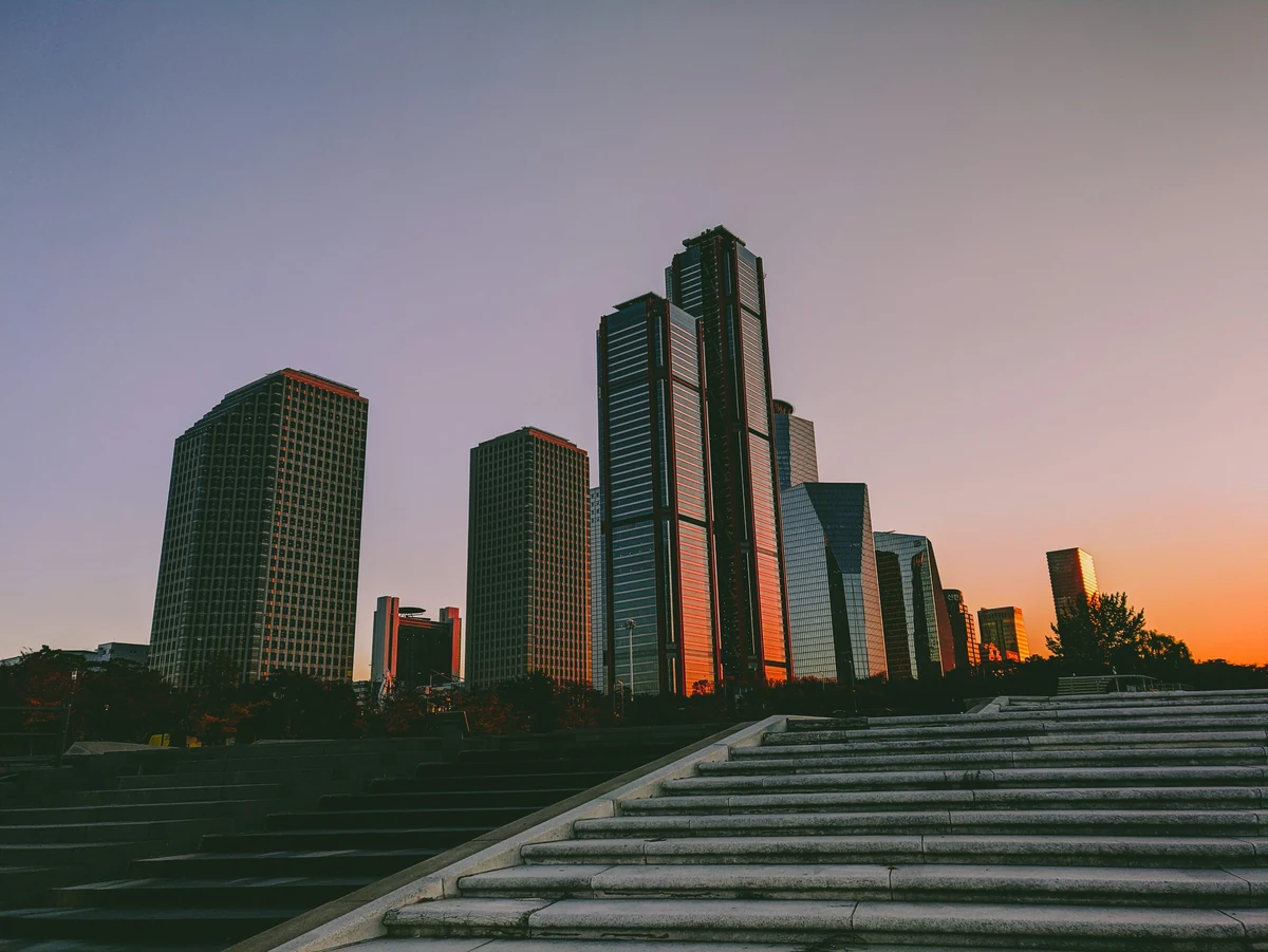 Broad park steps below the Yeouido skyline at sunset.