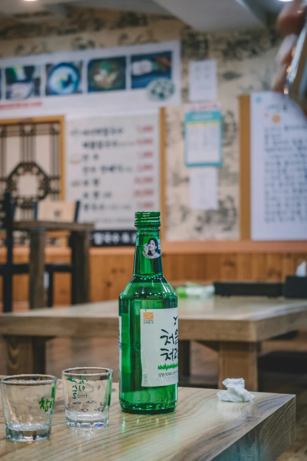 Soju and small glasses on a restaurant table in Uijeongbu, Korea.