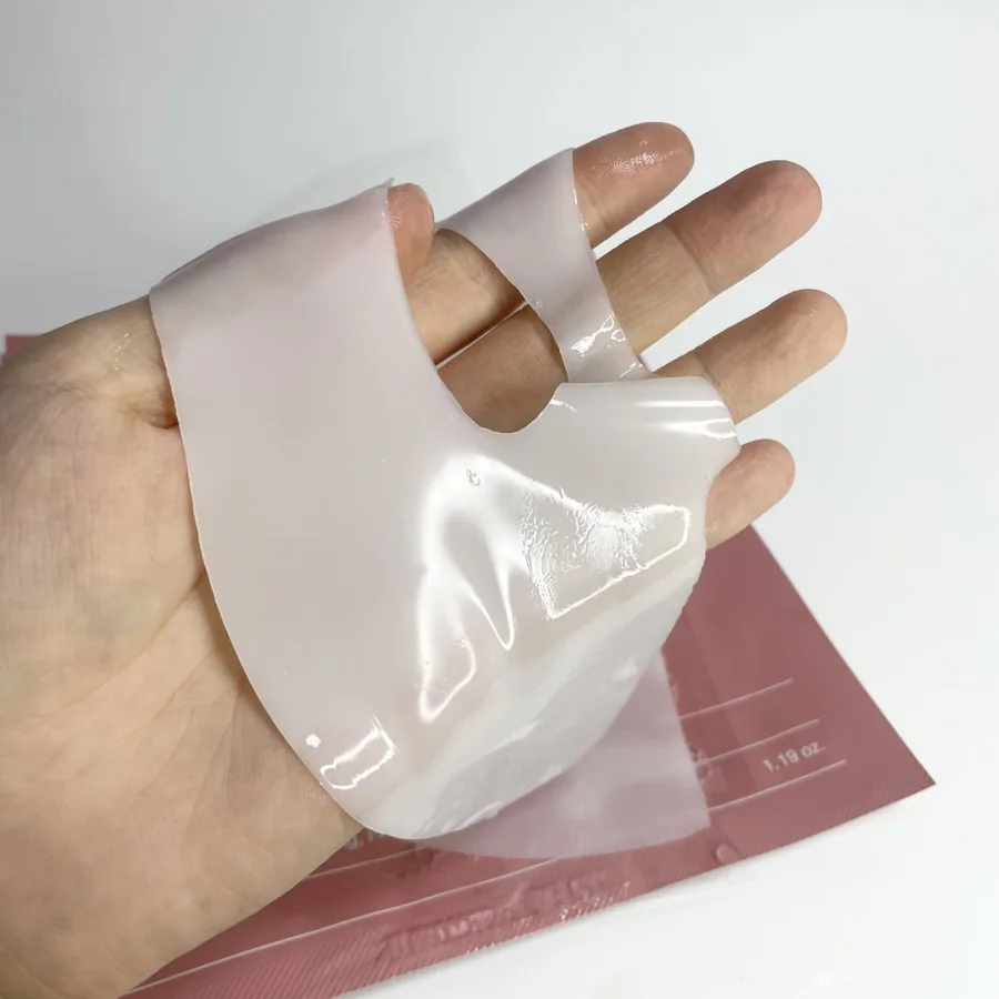 Lower section of the original Biodance hydrogel mask held in a hand, with the mouth opening visible