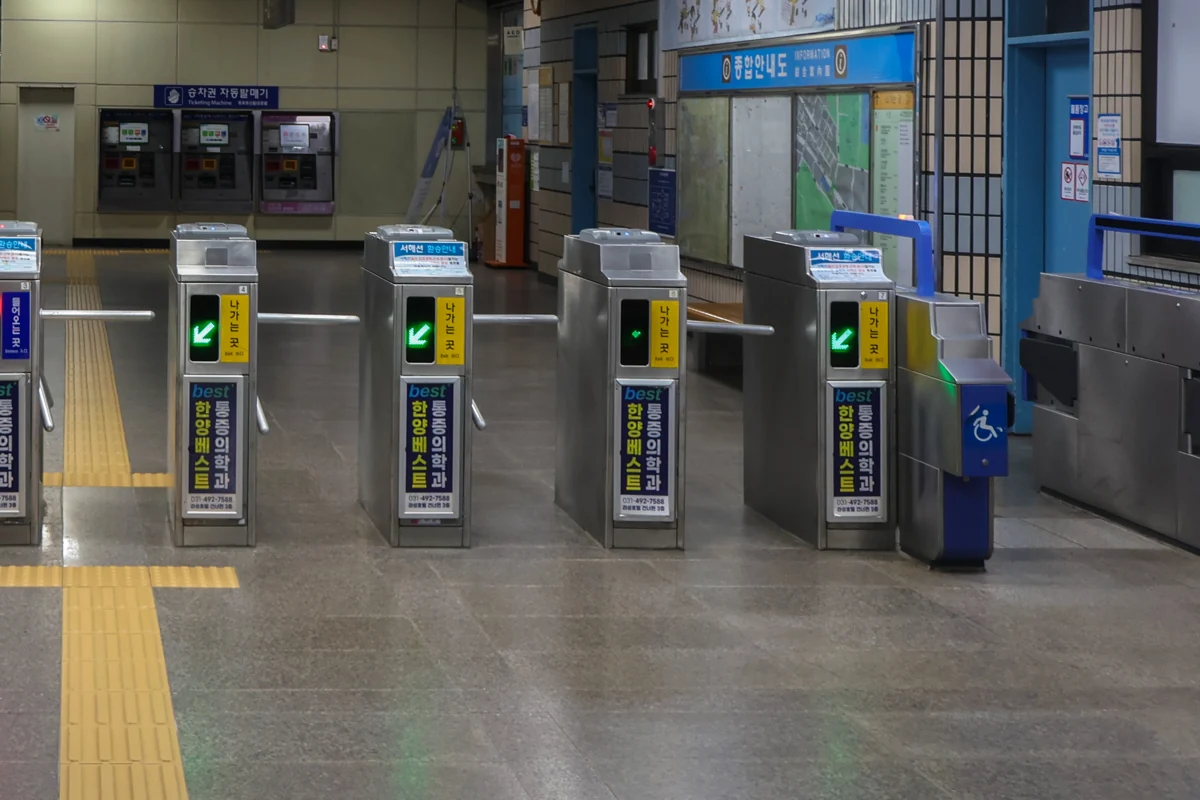 Close-up of subway gate card readers with green and red lane indicators.