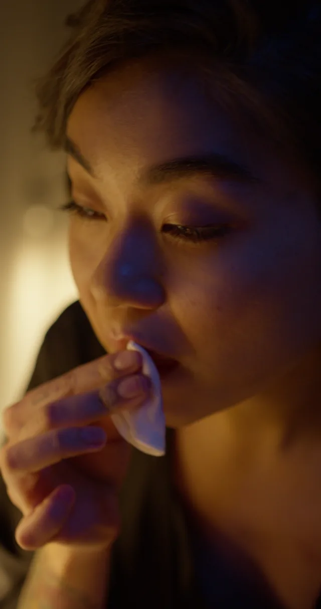 A cotton pad against the lips during makeup removal.