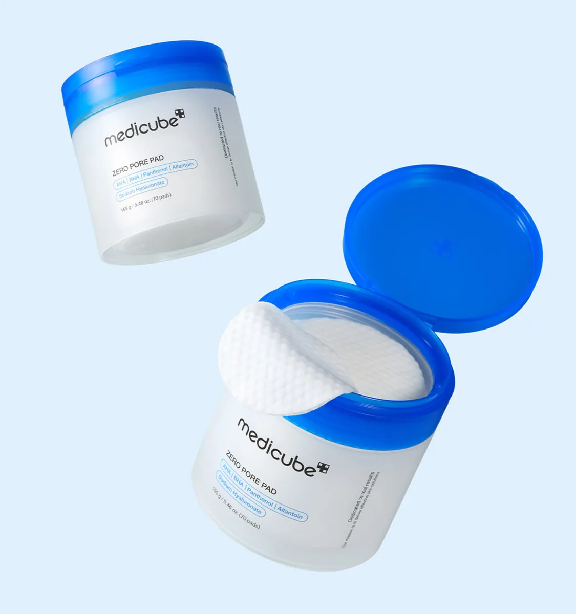 Two medicube Zero Pore Pad jars, one closed and one open with the blue lid flipped up and a pad lifted from the stack