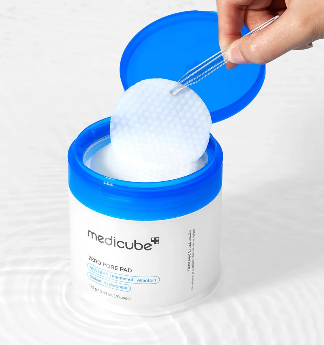 Tweezers lifting one pad out of the medicube Zero Pore Pad jar
