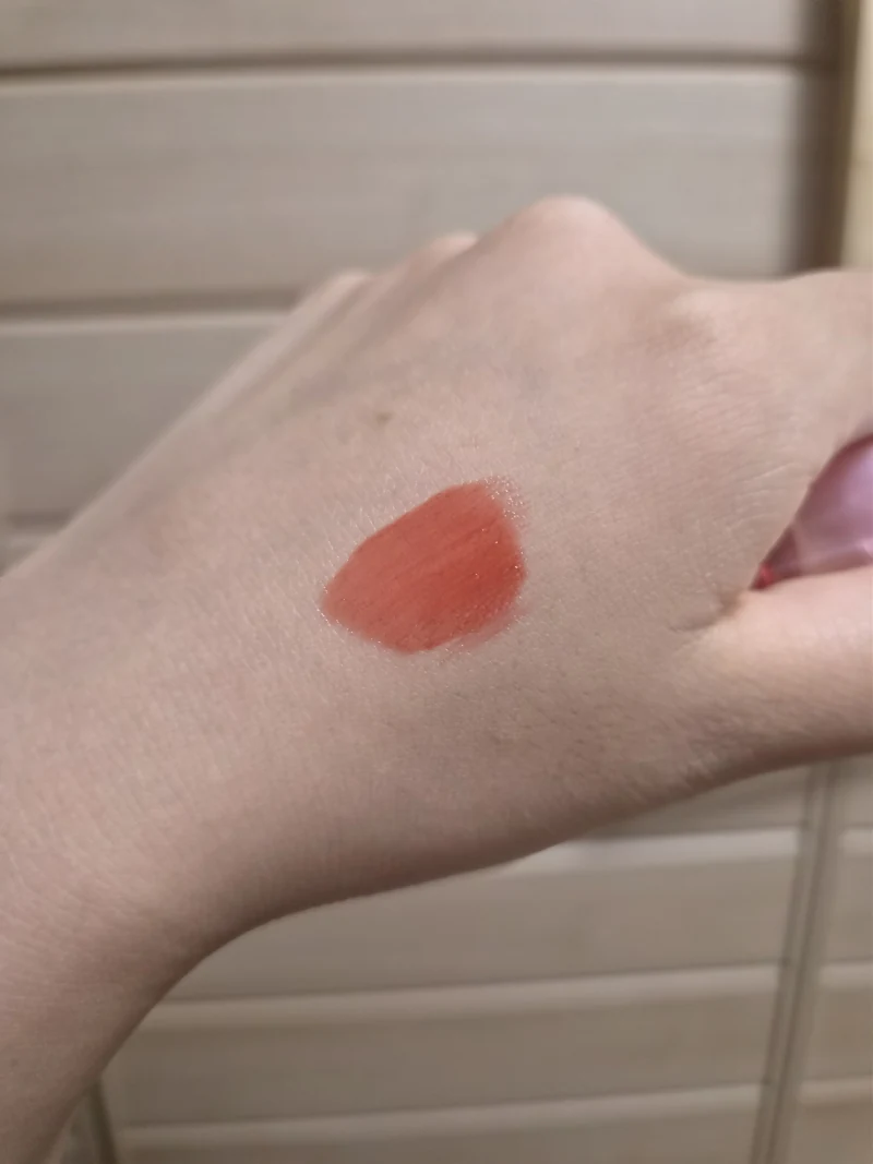 Back of a hand with older Peripera Ink Mood Glowy Tint 024, a glossy coral swatch