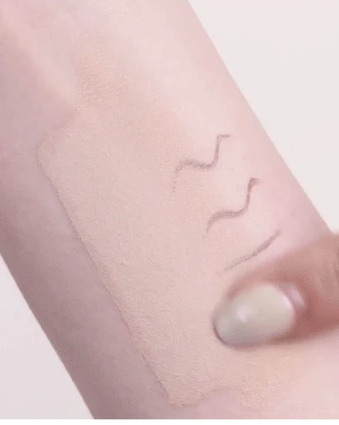 A fingertip blending The Saem Tip Concealer on skin.